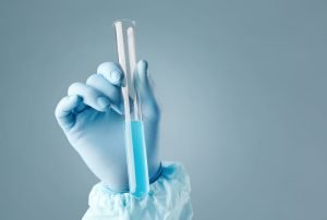 Hand,Holding,A,Test-tube,With,Cyan,Liquid