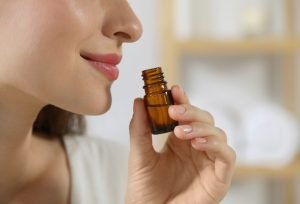 Young,Woman,Smelling,Essential,Oil,On,Blurred,Background,,Closeup.,Space