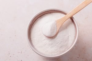 Collagen,Powder,And,Spoon,On,Beige,Stone,Background,,Top,View